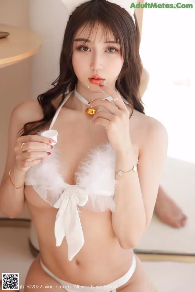 A woman in a white lingerie holding a cup of coffee.