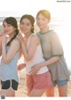 A group of young women standing next to each other on a beach.