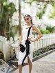 A woman in a white dress is posing for a picture.