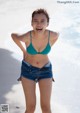 A woman in a blue bikini standing on a beach.