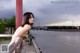 A woman leaning against a railing by the water.