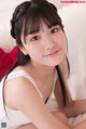 A young woman sitting on top of a white couch.