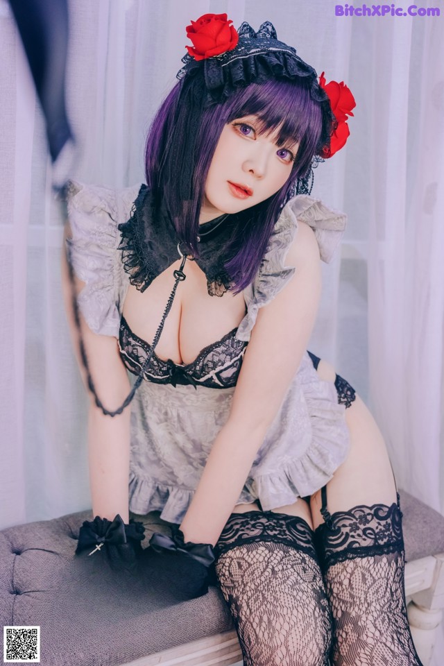 A woman in lingerie sitting on a chair with a rose in her hair.
