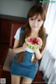 A young woman holding a slice of watermelon in her hand.