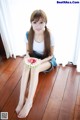 A woman sitting on the floor eating a slice of watermelon.