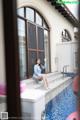 A woman sitting on the edge of a swimming pool.