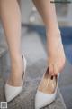 A close up of a woman's feet wearing white shoes.