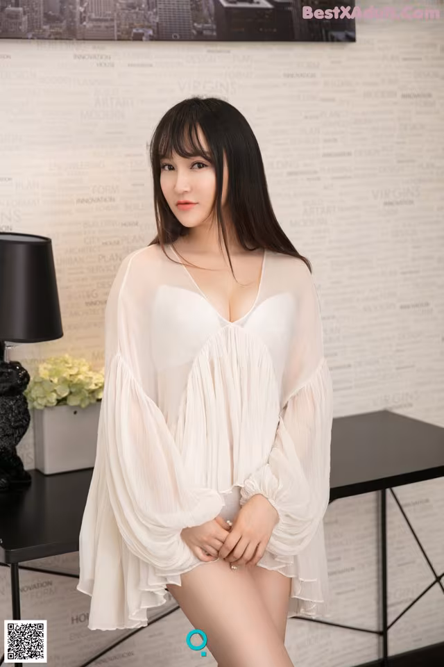 A woman in a white dress posing for a picture.
