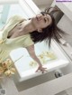 A woman in a yellow dress standing in a bathtub.