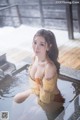 A woman in a yellow dress sitting in a hot tub.