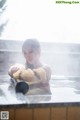 A woman in a bathtub with steam coming out of it.