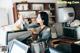 A woman standing behind a counter with a coffee grinder.