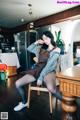 A woman sitting on a chair in a kitchen.