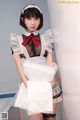 A woman in a maid outfit is posing for the camera.